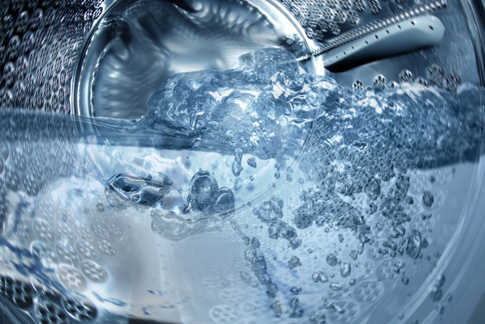 Sudsy water inside a washing machine drum at EveryBuddy's Laundromat